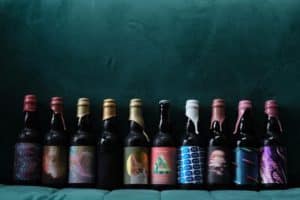 Bottles of beer lined against a wall.