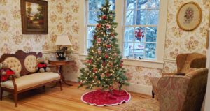 Sitting room decorated with Christmas tree and teddy bears in front of window facing the garden.