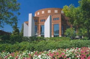 Greenville's Peace Center with greenery and flowers under a blue sky.