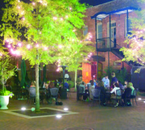 Patio dining at night under twinkle light trees.