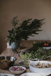 Table top of fresh and dried herbs in bowls.