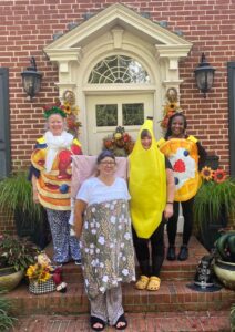Women dressed in food themed costums in front of front door.