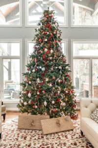 Decorated Christmas tree in well lit room with gifts underneath