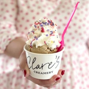 Scoop of ice cream in a cup with whipped cream and sprinkles