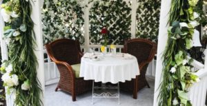 Table for two set outside with ivy background