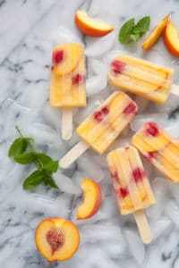 Peach Sangria Popsicles on marble counter