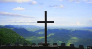 Cross at Pretty Place Chapel overlooking Blue Ridge Mountians with blue sky.