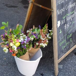 Multicolored bouquet in bucket near chalkboard sign