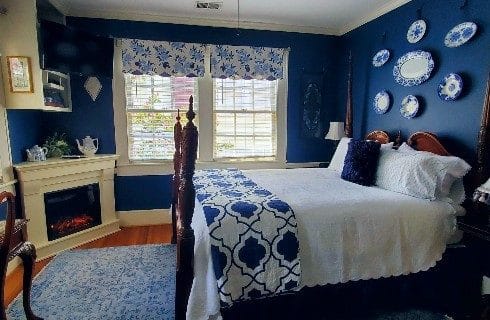 Four poster queen bed near corner fire place.