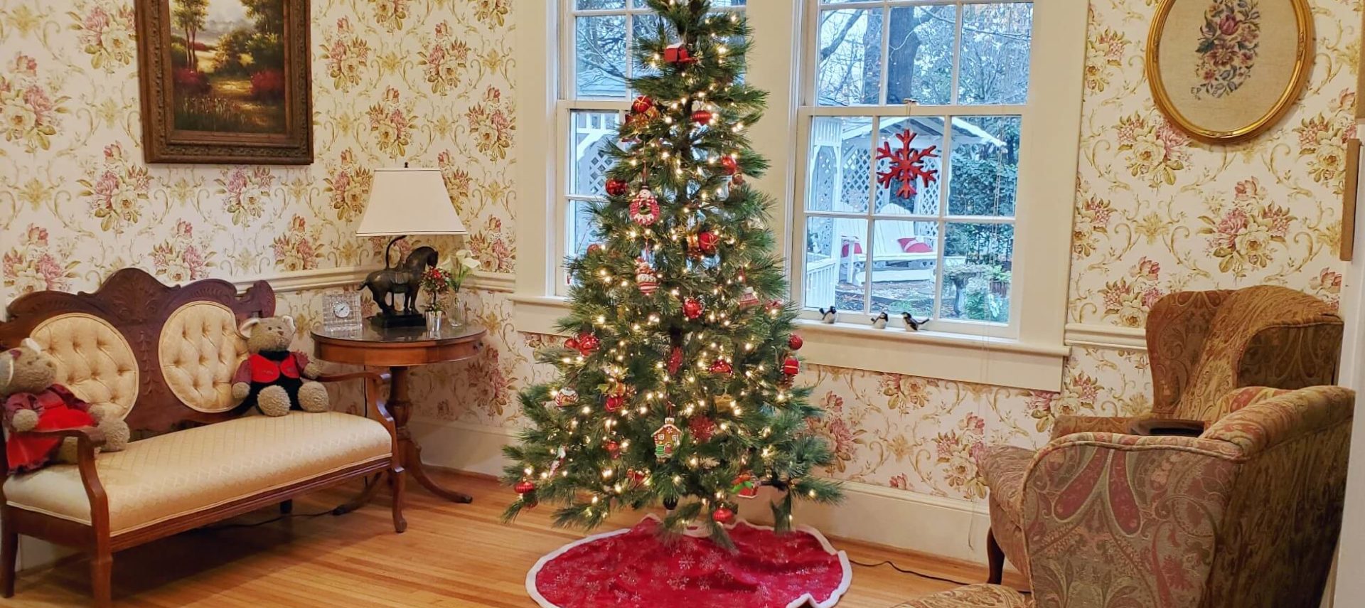 Sitting room decorated with Christmas tree and teddy bears in front of window facing the garden.