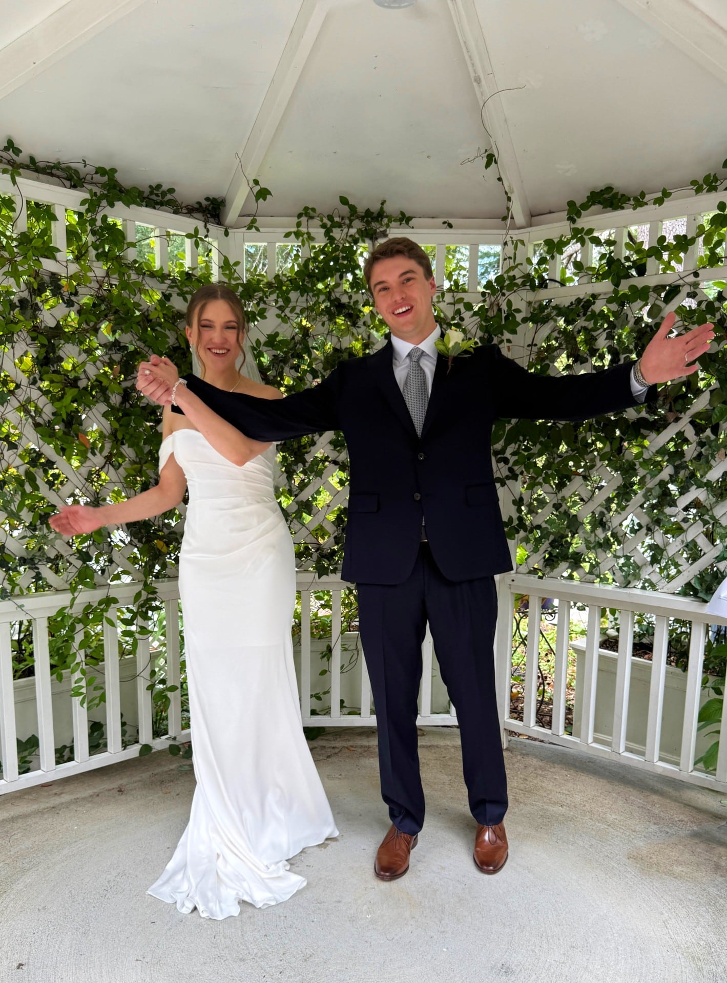Bride and groom under gazebo celebrating.