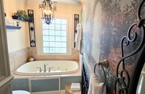 Two person jetted tub under iron chandelier