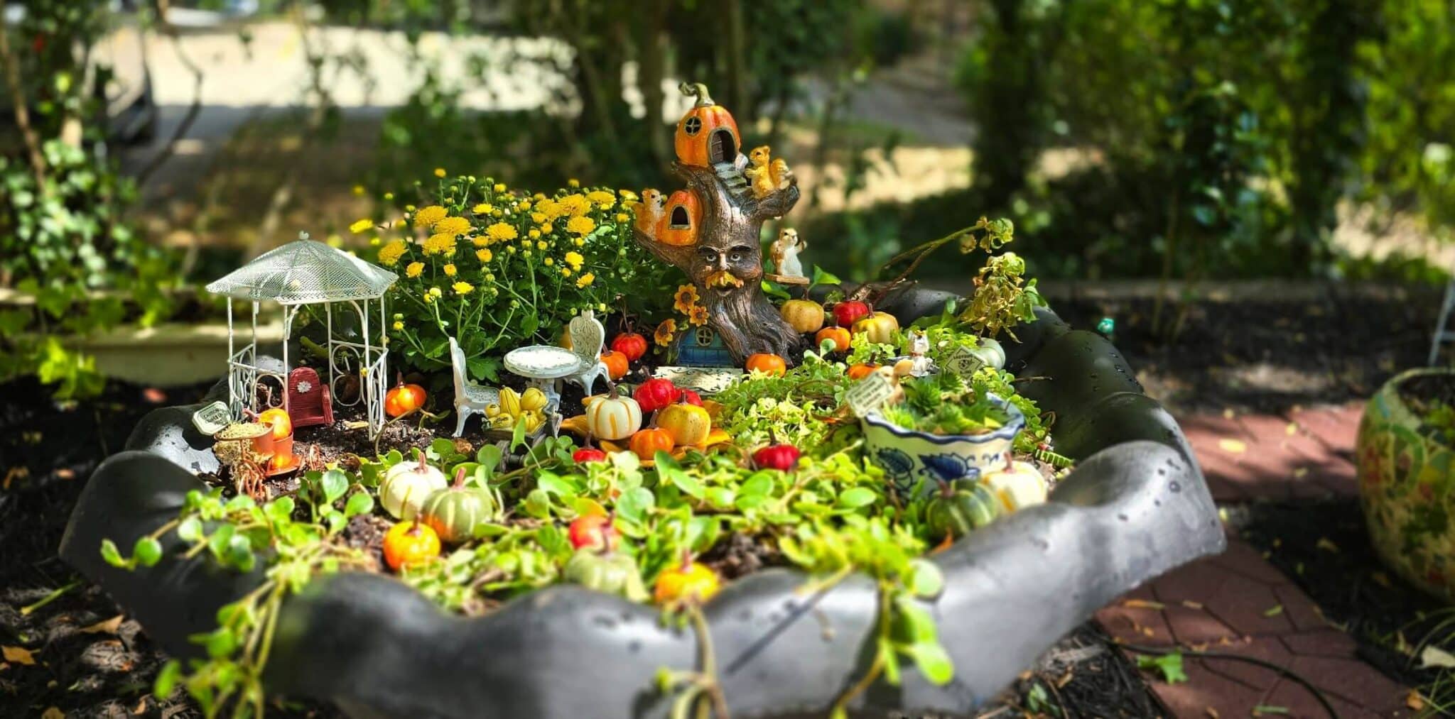 Fountain fairy garden decorated with pumpkins for the fall.