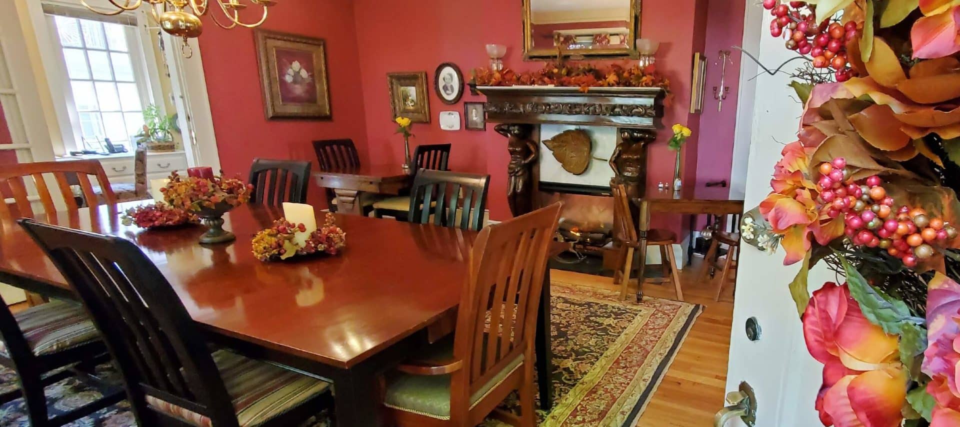 Wooden table behind open door with fall decorations