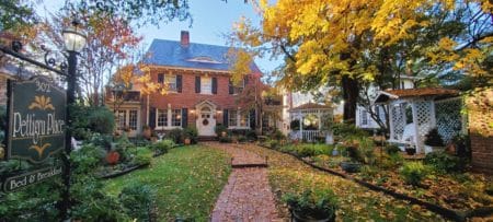 Red brick inn with fall colored leaves in the garden