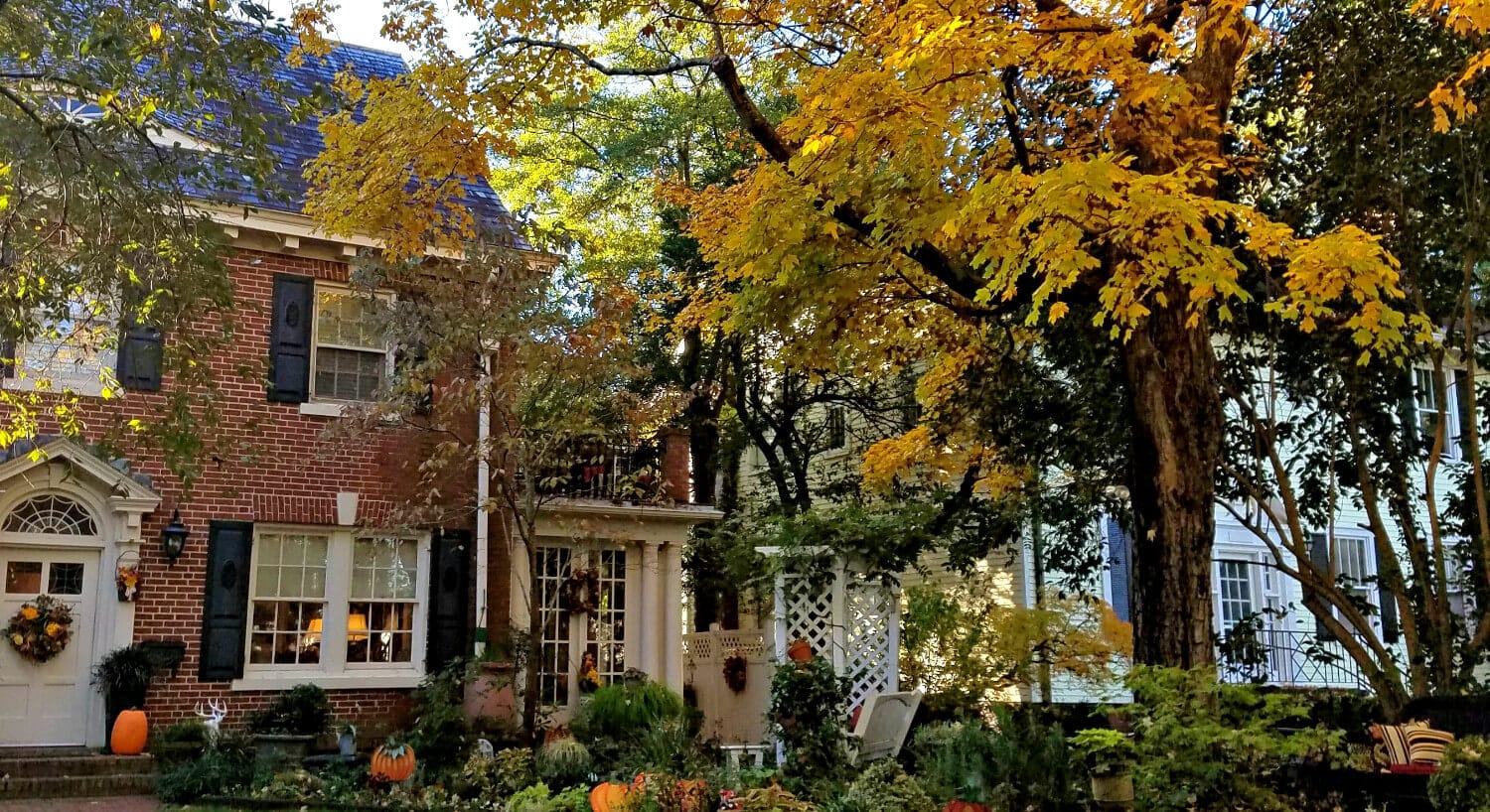 Large brick home in autumn with fall foliage in front. 