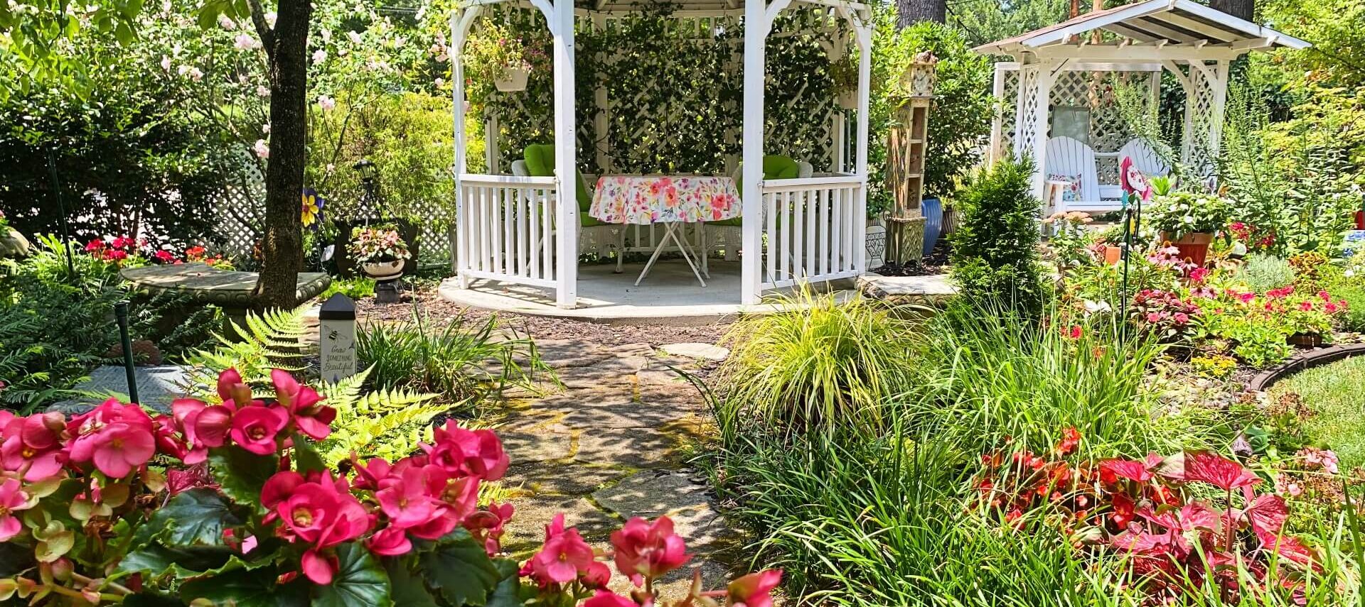 Beautiful blooming garden with gazebo and glider for two.