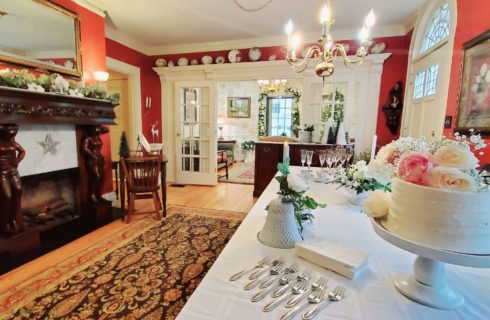 Dining room decorated for wedding with flower topped cake