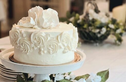 White wedding cake with floral background and champagne glasse