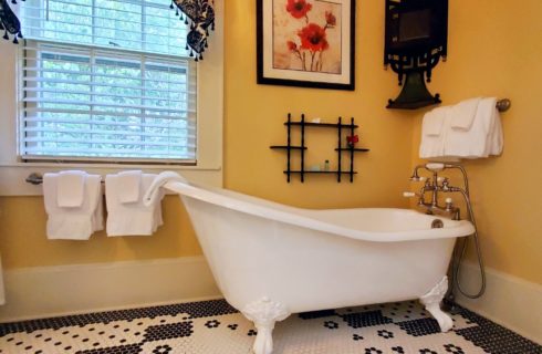 Slipper clawfoot tub in large tiled bathroom