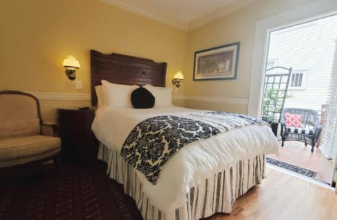 Queen bed with quality linen and open patio door.