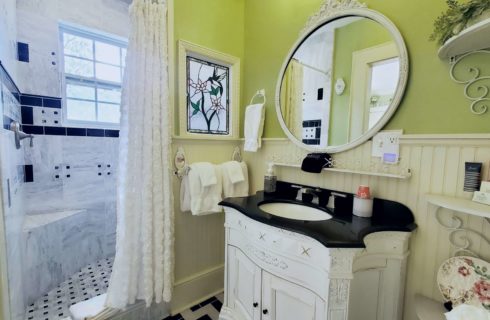 Large vanity sink and mirror with shower bench.
