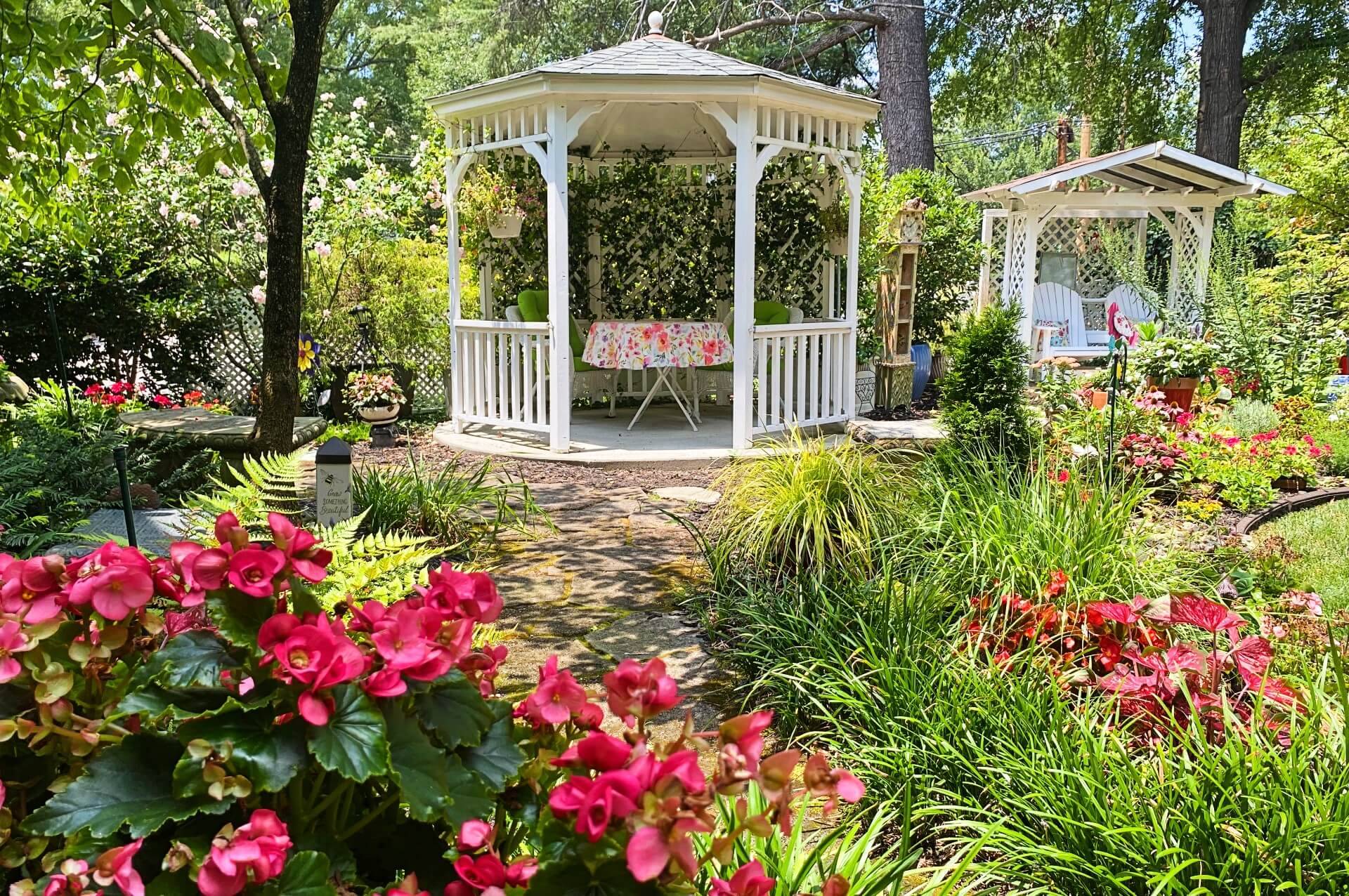 Beautiful blooming garden with gazebo and glider for two. 