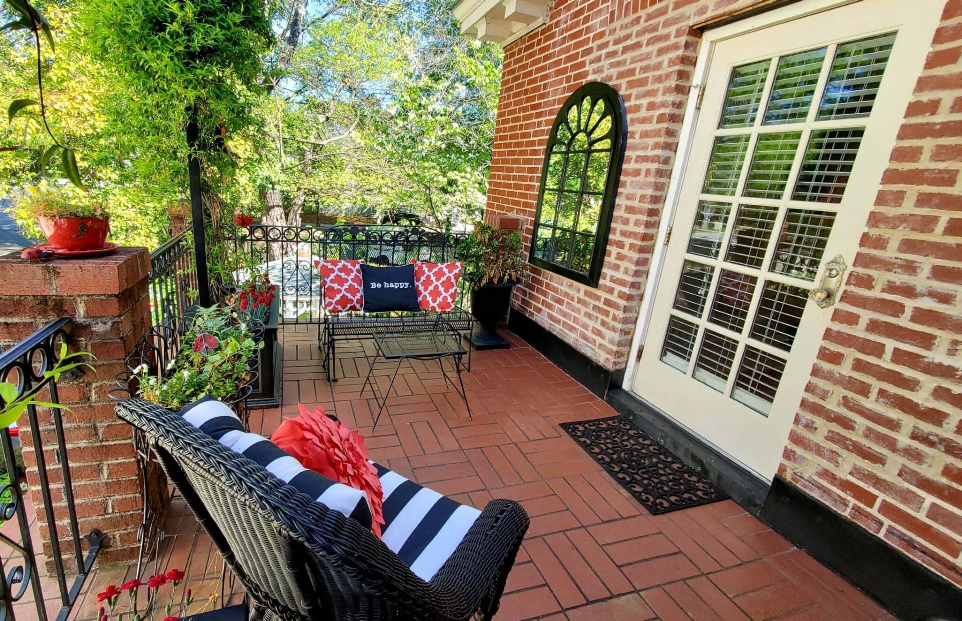Second floor balcony with plants and seating. 