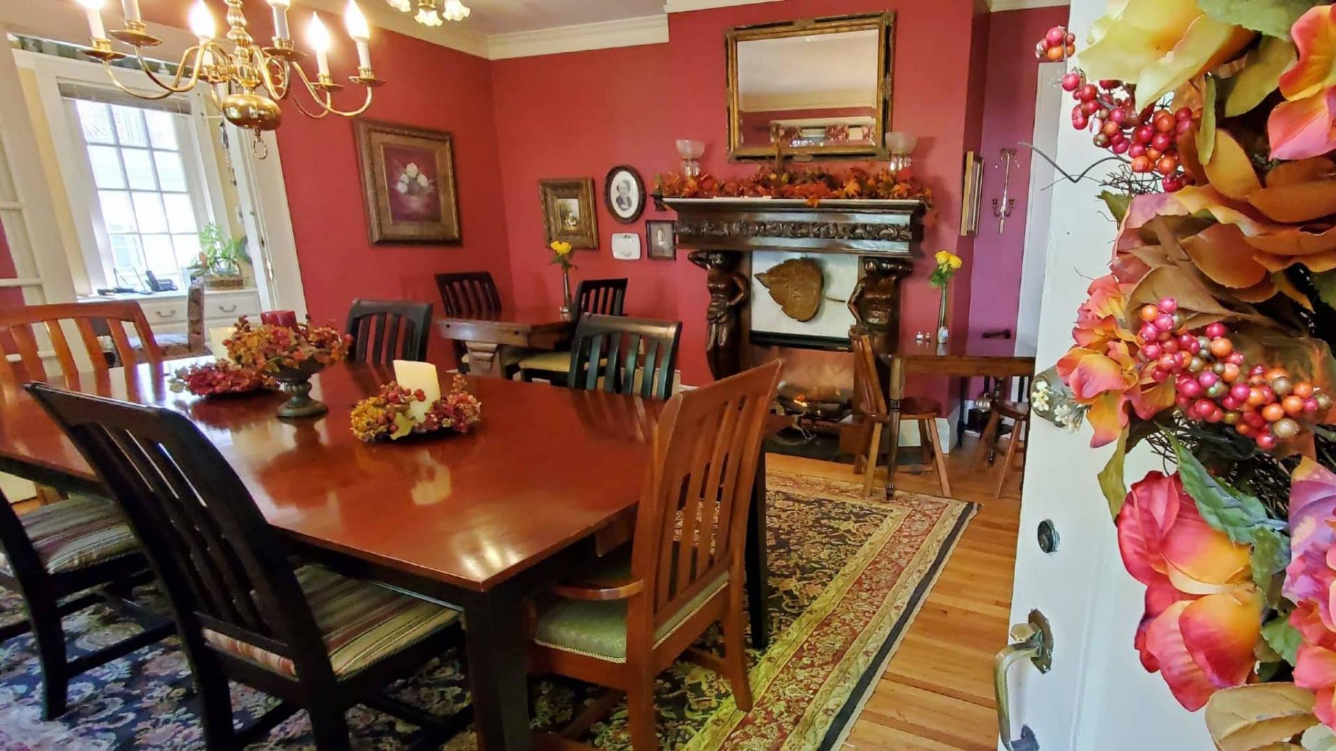 Three dining room tables with lit fireplace decorated for fall
