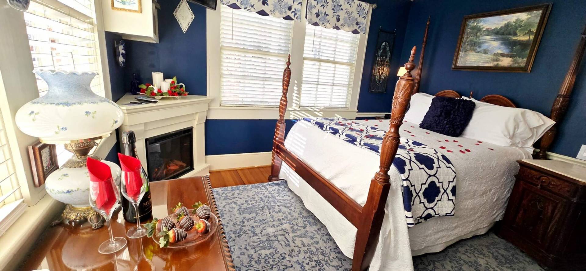Queen room with silk rose petals, chocolate dipped strawberries, and fireplace.