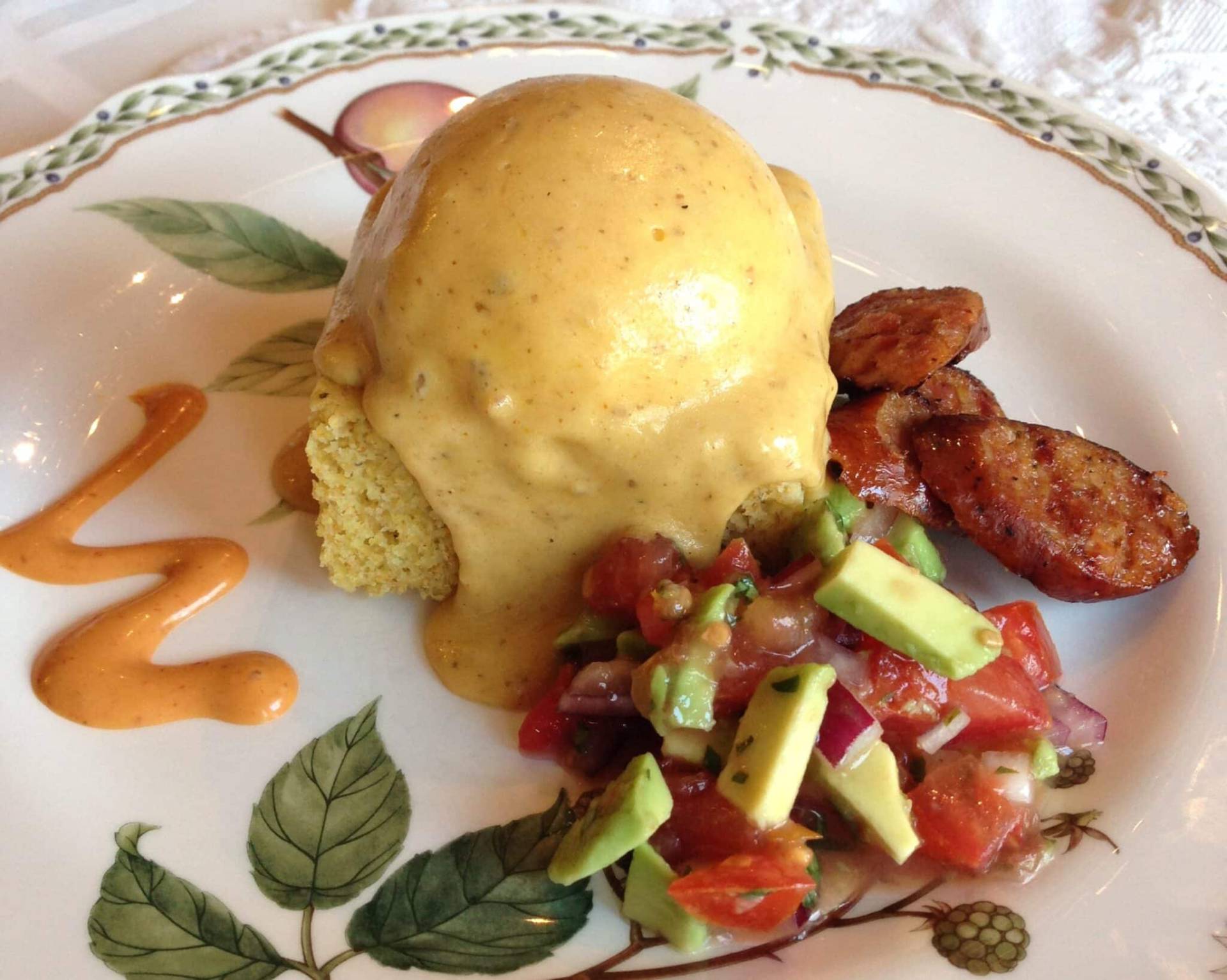 Poached egg with andouille sausage and avocado salsa in fine china
