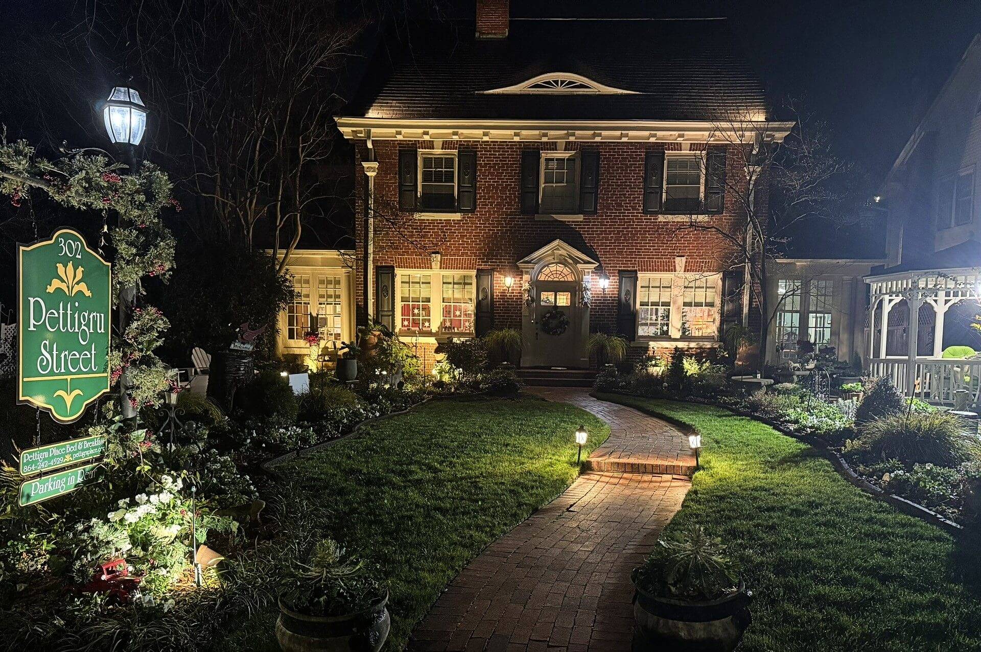 House well lit at night with red brick path