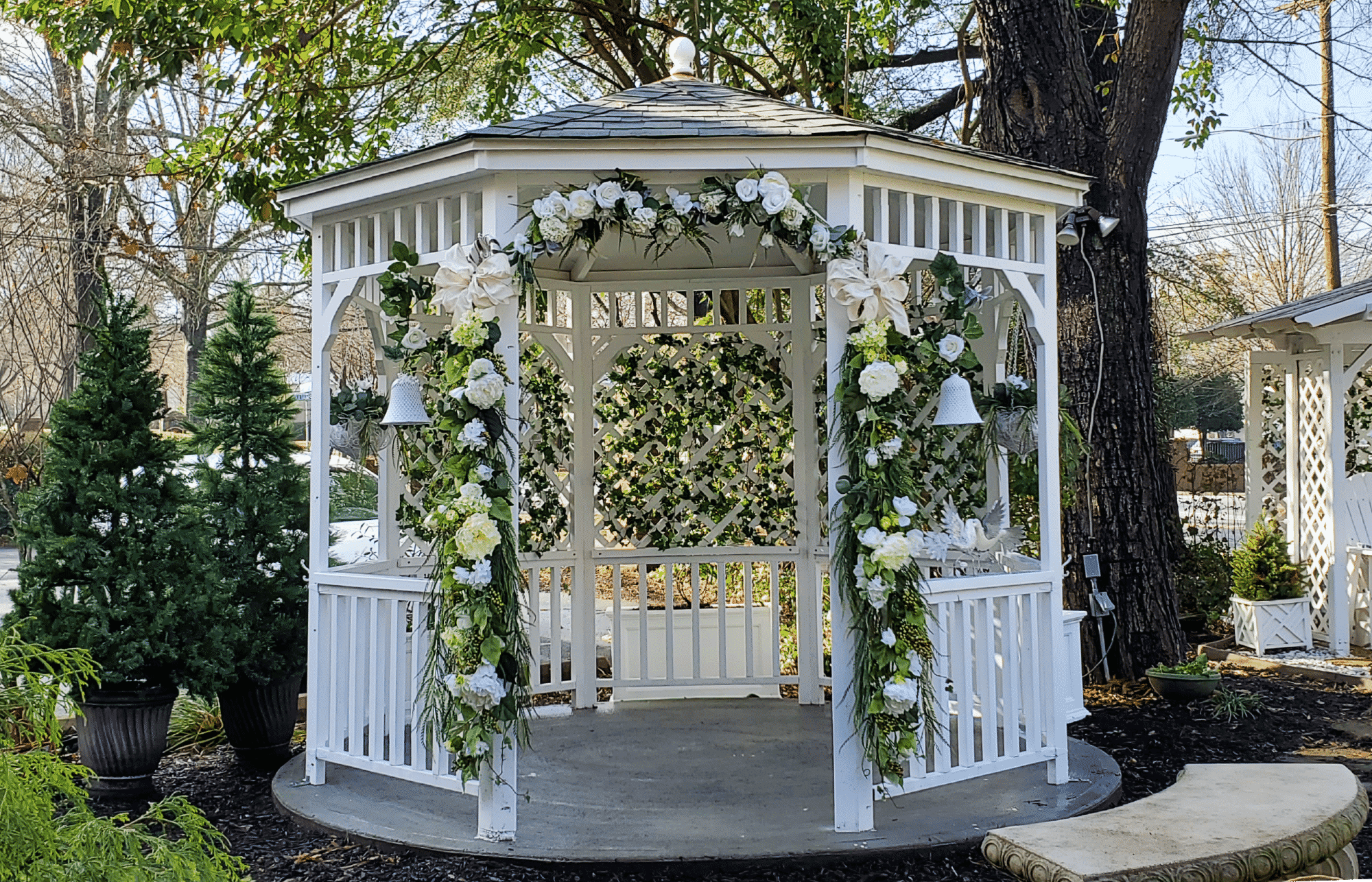 White gazebo with floral decorations for wedding ceremonies.